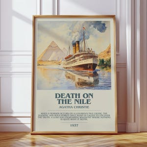 May include: A framed poster with a watercolour painting of a cruise ship on a river, with pyramids in the background. The poster is titled "Death on the Nile" by Agatha Christie, with text below. The poster is in a wooden frame.
