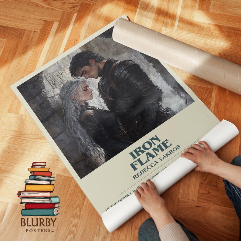 May include: A rolled poster featuring a romantic illustration of a man and woman, with the title "Iron Flame" and author Rebecca Yarros. The poster has a light beige background and is being unrolled. A stack of books is visible.
