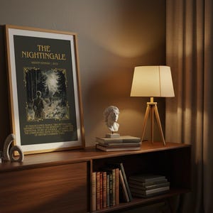 Peut inclure: Une affiche encadr&eacute;e avec le titre "THE NIGHTINGALE" en lettres dor&eacute;es, repr&eacute;sentant une illustration d'une personne dans une for&ecirc;t. L'affiche est expos&eacute;e sur un meuble en bois, avec une lampe, des livres et des bustes.