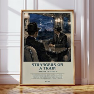 May include: A framed poster featuring a scene of two men in suits and hats sitting at a table inside a train car at night. The text reads Strangers on a Train, Patricia Highsmith, a summary of the plot, and the year 1950 in a light beige border.