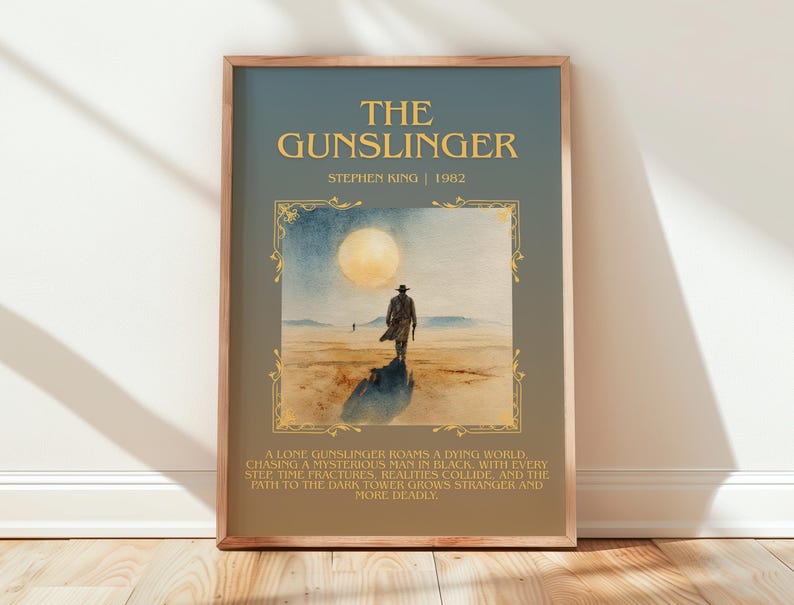 May include: Framed art print of "The Gunslinger" by Stephen King. The artwork depicts a lone figure walking towards a large moon in a desert landscape. The title and author's name are displayed in gold lettering.