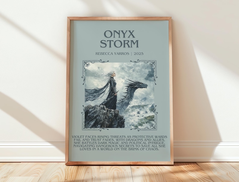 May include: Framed art print titled "Onyx Storm" by Rebecca Yarros, 2025. The artwork features a woman in a flowing black gown standing on a rocky outcrop with a dragon. The background is a light blue with text describing the story.