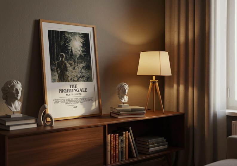 May include: A framed poster for "The Nightingale" movie, featuring a forest scene and the title text. The poster is displayed on a wooden cabinet with a lamp, books, and a bust sculpture. The room has a warm, inviting atmosphere.