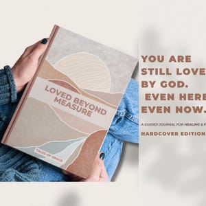 May include: A hardcover journal titled "Loved Beyond Measure" with a landscape design in neutral tones. The text "You are still loved by God. Even here. Even now." is also visible. The journal is a guided journal for healing and faith.