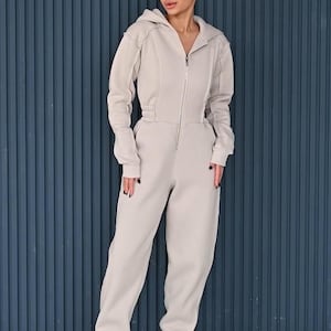 Women's cotton jersey one piece with zipper, full-length beige jumpsuit against blue background, comfortable casual overall, versatile lightweight romper