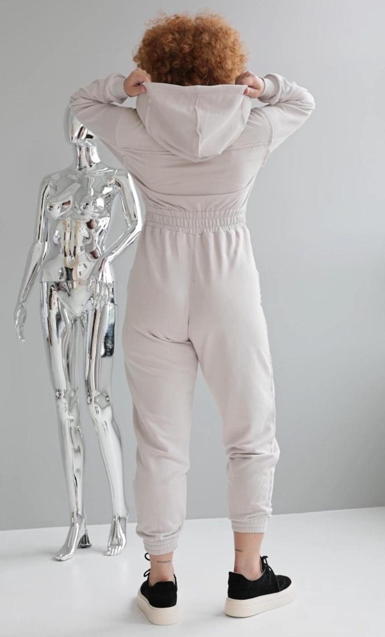 Beige hooded jersey jumpsuit, women's cotton one piece with back view, comfortable casual overall with elastic waist, lightweight leisure outfit