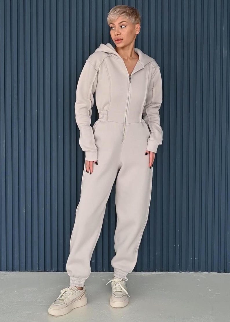 Women's cotton jersey one piece with zipper, full-length beige jumpsuit against blue background, comfortable casual overall, versatile lightweight romper