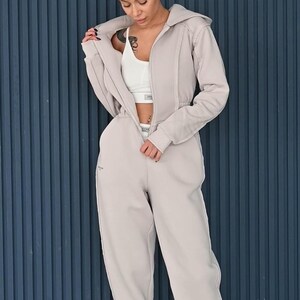 Lightweight beige jumpsuit styled with white top, women's cotton jersey overall with zipper, casual one piece loungewear, comfortable everyday romper