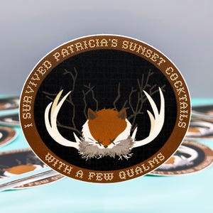 May include: A circular sticker with a brown border and black center. It features a central illustration of a fox head with white antlers and X-shaped eyes. The text reads: I SURVIVED PATRICIA'S SUNSET COCKTAILS WITH A FEW QUALMS in a pixelated font.