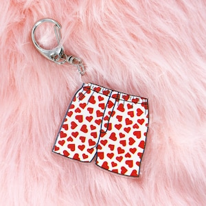 May include: A red and white heart-patterned keychain shaped like a pair of boxer shorts.