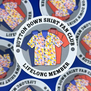 Könnte beinhalten: Runder Aufkleber mit dem Text "BUTTON DOWN SHIRT FAN CLUB LIFELONG MEMBER". Der Aufkleber zeigt Illustrationen von drei Hemden mit Knöpfen in Blau, Orange und einem geometrischen Muster aus Gelb, Blau und Orange.