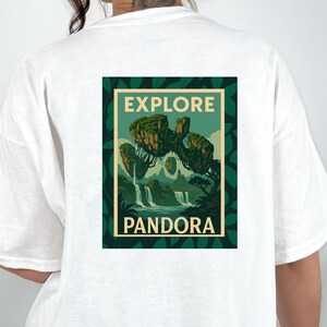 May include: White t-shirt with a rectangular graphic on the back. The graphic features the word "EXPLORE" above a landscape scene with waterfalls and floating islands. The word "PANDORA" is below the scene.