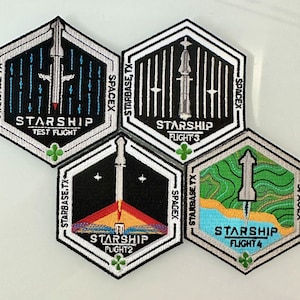 Puede incluir: Cuatro parches bordados hexagonales con bordes blancos y fondos negros. Cada parche presenta un cohete estilizado con el texto "STARSHIP" y un número de vuelo. Los parches están etiquetados con "STARBASE TX" y "SPACEX".