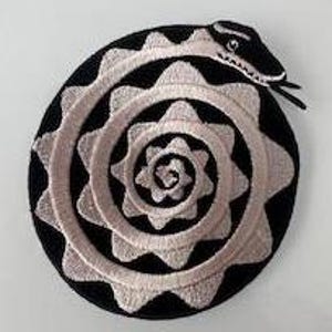 Puede incluir: Un parche bordado en blanco y negro con una serpiente blanca enroscada en espiral.