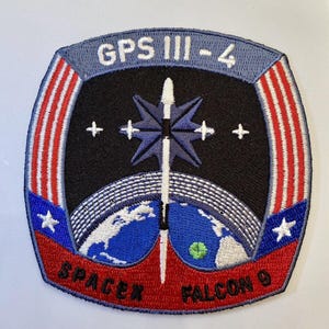 May include: Embroidered patch featuring the text "GPS III-4" and "SpaceX Falcon 9". The patch has a black background with a stylized rocket, a blue and white globe, and a starburst design. The border is red, white, and blue.