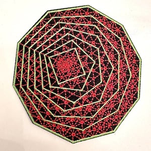 Op de afbeelding: Een zwart en rood geborduurd embleem met een geometrisch ontwerp. De patch heeft een reeks geneste achthoeken, met rode bloempatronen op een zwarte achtergrond. De randen zijn groen omlijnd.