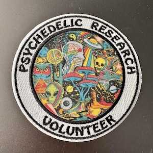 May include: Embroidered patch with the words "PSYCHEDELIC RESEARCH VOLUNTEER" in a circular design. The patch features a colorful illustration of an owl, alien, mushrooms, and other psychedelic imagery.