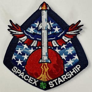 May include: Embroidered patch featuring a rocket ship design with a red and white color scheme. The patch includes the text "SPACEX STARSHIP" and a stylized American flag and wings.