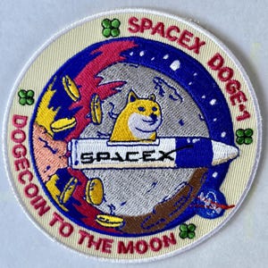 May include: Embroidered patch with a circular design featuring a yellow Shiba Inu dog in a rocket ship. The patch includes the text "SPACEX DOGE-1" and "DOGECOIN TO THE MOON" in a blue, red, and yellow color scheme.