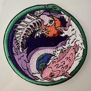 May include: Embroidered patch featuring a yin-yang design with fish and a dragon. The design includes a skeleton fish, a pink fish, and a green dragon, all set against a dark blue background with a green border.