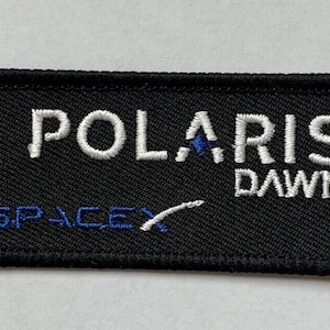May include: Black embroidered patch with white text that reads "POLARIS DAWN" and a blue and white SpaceX logo.