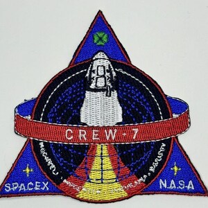 May include: A blue, red and white embroidered patch featuring a space shuttle, a globe and the text "CREW-7" in the centre. The patch also includes the logos for SpaceX and NASA.