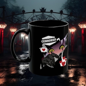Puede incluir: Una taza de cerámica negra con un gráfico de un personaje estilizado de ojos amarillos y manos oscuras que se extienden. El diseño incluye un bocadillo blanco con el texto CENSORED, pequeños corazones rojos y formas oscuras y dentadas.
