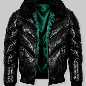 May include: A black puffer jacket featuring a textured snakeskin pattern, a thick black faux fur collar, and a vibrant emerald green satin lining. The jacket includes a front zipper closure, long sleeves with ribbed cuffs, and a ribbed hem.
