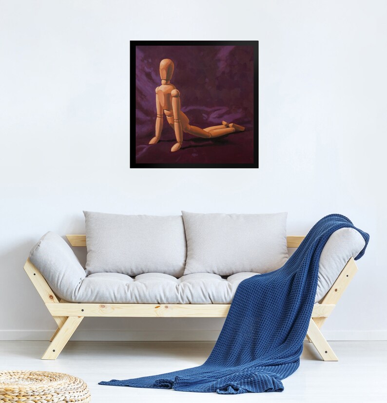 May include: A wooden artist's mannequin posed in a kneeling position on a purple fabric background. The mannequin is made of wood and has a natural finish.