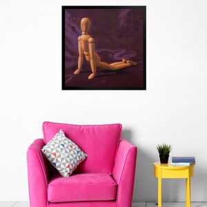 May include: A wooden artist's mannequin posed in a kneeling position on a purple fabric background. The mannequin is made of wood and has a natural finish.