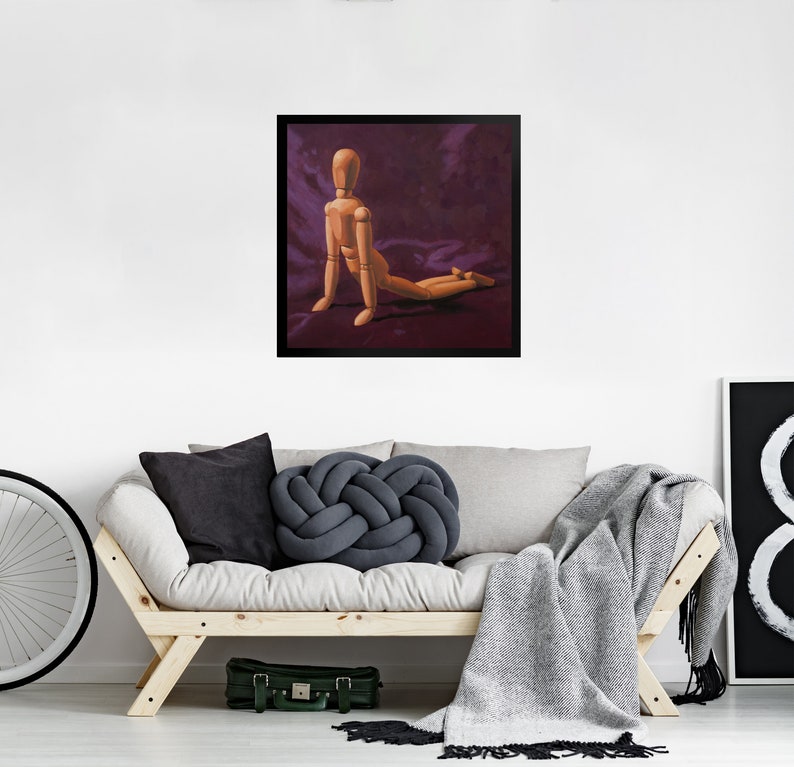 May include: A wooden artist's mannequin posed in a kneeling position on a purple background. The mannequin is made of wood and has a natural finish.