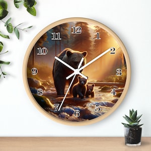 May include: A round wall clock with a brown wooden frame and a white face. The clock features a picture of a brown bear and two cubs in a forest setting. The numbers 1 through 12 are printed in black on the clock face.
