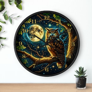 May include: A round wall clock with a black frame featuring an owl perched on a tree branch under a full moon. The owl has brown and white feathers, and the background is a starry night sky. The clock hands are black.