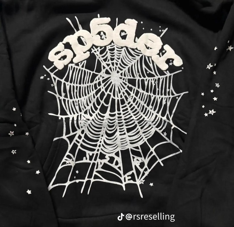 Puede incluir: Sudadera negra con un dise&ntilde;o de telara&ntilde;a blanca y el texto "sp5der" en la parte superior. Peque&ntilde;as estrellas blancas adornan la prenda. El identificador de Instagram "@rsreselling" es visible en la parte inferior.