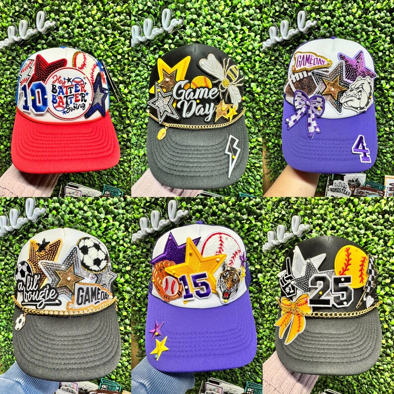 May include: A selection of baseball caps with diverse designs. Each cap showcases a unique colour palette, adorned with stars, sports-themed patches, and text such as "Game Day" or numbers. The caps have a curved peak and a structured crown.