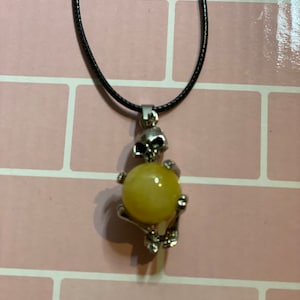 Labradorite sphere with skull wrapped around (hugging) it