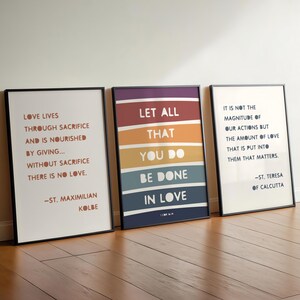 May include: Three motivational quotes printed on white paper with black frames. The quotes are: "Love lives through sacrifice and is nourished by giving... Without sacrifice there is no love. -St. Maximilian Kolbe", "Let all that you do be done in love. 1 Cor 16:14", and "It is not the magnitude of our actions but the amount of love that is put into them that matters. -St. Teresa of Calcutta".