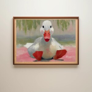 Puede incluir: Pintura enmarcada de un pato blanco con pico y patas rojas. El pato est&aacute; sentado sobre una superficie rosa, con un fondo verde y azul. La pintura est&aacute; en un marco de madera.