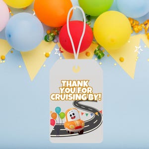 May include: A white thank you tag with a yellow car and balloons on a road. The text on the tag reads "Thank you for cruising by!"