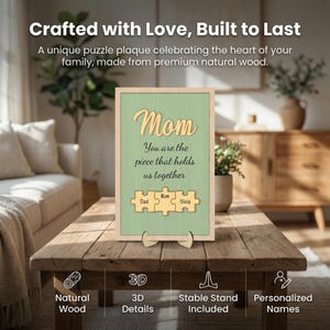 K&ouml;nnte beinhalten: Holztafel mit dem Wort "Mom" in Schreibschrift und dem Text "You are the piece that holds us together." Darunter Puzzleteile mit den Namen Dad, Mom und Olivia. Die Tafel steht auf einem Holzst&auml;nder.