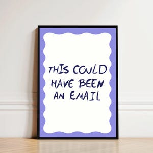 Può includere: Una stampa incorniciata con la scritta "THIS COULD HAVE BEEN AN EMAIL" in lettere blu scuro. La stampa ha uno sfondo bianco con un bordo ondulato viola chiaro e una cornice nera. La stampa è appoggiata a un muro bianco.