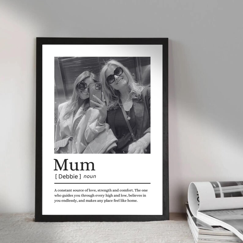 May include: Black and white framed print featuring a photograph of two people taking a selfie. The print includes the word "Mum" with a definition below, describing a constant source of love and strength.