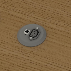 May include: Three grey circular electrical outlet covers with various ports, including Ethernet and power, are arranged on a wooden surface. The covers are evenly spaced, with a focus on functionality and design.