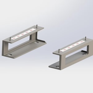 Puede incluir: Dos soportes metálicos grises con diseño en forma de C. Cada soporte tiene una tira de cinta blanca con texto rojo y dos tornillos. Los soportes están diseñados para montaje e instalación.