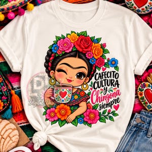 Puede incluir: Una camiseta blanca con un gráfico colorido de una persona con corona de flores sosteniendo una taza de café. El texto dice CAFECITO CULTURA y Chingona siempre. El diseño incluye flores vibrantes rojas, rosas, naranjas y azules.