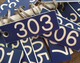 Vintage blue motel key with white number and key ring in the 300 and 400 range of numbers