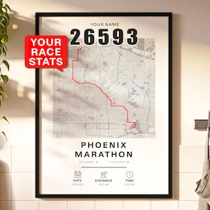 May include: Black framed print featuring a map of the Phoenix Marathon course with a red route line. The print includes the text "YOUR NAME" and "26593" at the top, and "PHOENIX MARATHON" at the bottom. Additional details include date, distance (26.2 mi), and time.