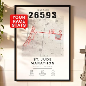 Puede incluir: Una impresión enmarcada con un mapa de ruta de carrera rojo, con el texto "ST. JUDE MARATHON." La impresión incluye el nombre del corredor, el número de carrera 26593 y las estadísticas de la carrera. La distancia es de 42,16 kilómetros, y el tiempo es de 3:21:05.