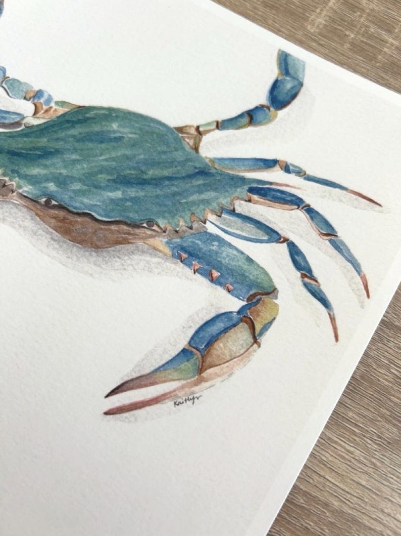 May include: Watercolour painting of a blue crab. The crab is rendered in shades of blue, green, and brown, with detailed brushstrokes. The artwork is on white paper, with a signature in the bottom right corner.