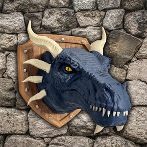 May include: A blue dragon head mounted on a wooden plaque with a shield design. The dragon has white horns and sharp teeth.